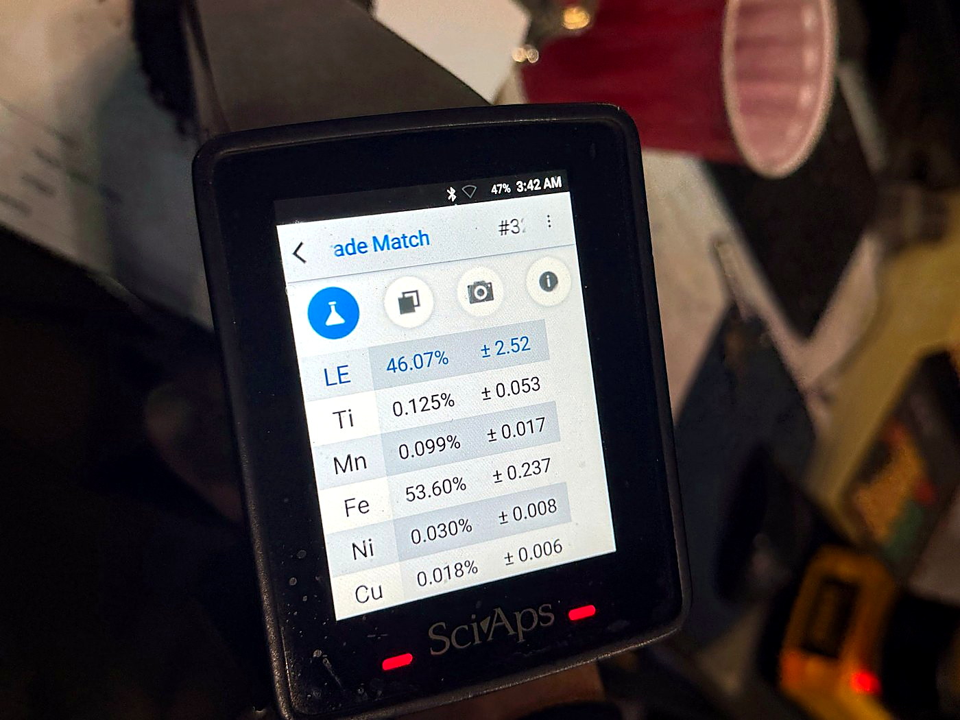 A handheld elemental analyser showing a multi-element field assay readout for iron, copper and nickel