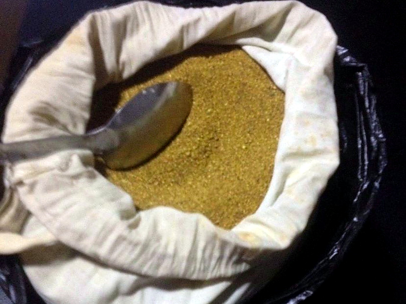 Fine golden gold dust concentrate in an open sample bag after mercury-free gravity separation